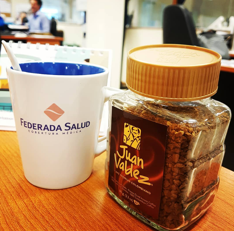 Taza de Federada Salud sobre un escritorio de oficina